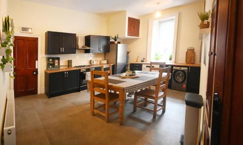 a kitchen with a table and chairs in a kitchen at Hope House, Hebden's Hidden Gem in Hebden Bridge