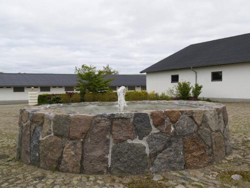 a stone fountain in the yard of a house at Juhl's Bed & Breakfast in Kolding