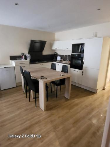une cuisine avec une table et des chaises dans une pièce dans l'établissement Appartement St cyprien plage 66750, à Saint Cyprien Plage
