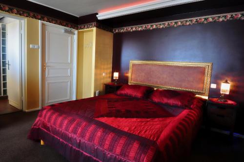 a bedroom with a large bed with a red bedspread at Pension & Spa de Watertoren in Zandvoort