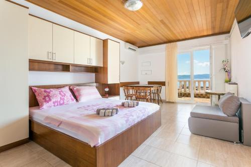 Schlafzimmer mit einem Bett, einem Tisch und Stühlen in der Unterkunft Apartments by the sea Brela, Makarska - 18356 in Brela