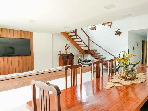 a kitchen and dining room with a wooden table at Casa Beira Mar Angra in Angra dos Reis