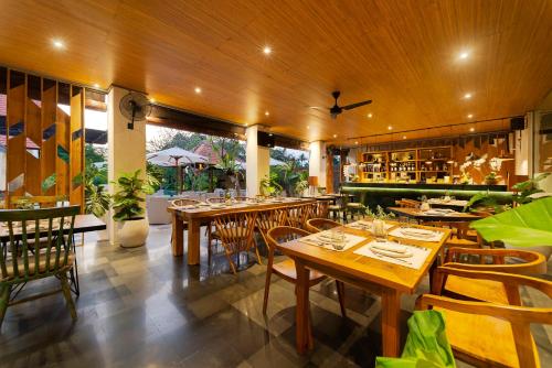 a dining room with wooden tables and chairs at Adepa Resort in Canggu