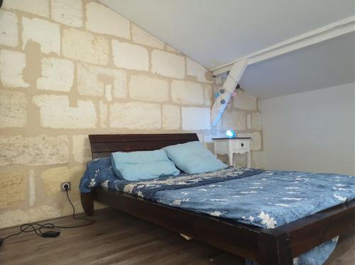 un lit dans une chambre avec un mur de briques dans l'établissement Échoppe bordelaise avec jardin et piscine, à Bègles