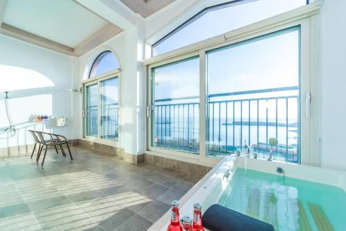 een grote badkamer met een bad en een groot raam bij Goonghang Resort in Buan