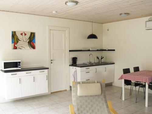 a kitchen with white cabinets and a table with a tablecloth at Juhl's Bed & Breakfast in Kolding