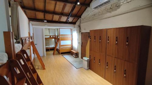 a room with wooden cabinets and a room with a staircase at Old Place Hostel in Kaohsiung