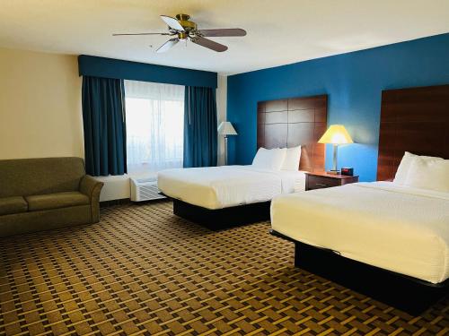 um quarto de hotel com duas camas e um sofá em Baymont by Wyndham La Crosse/Onalaska em Onalaska