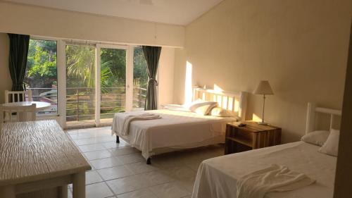 a hotel room with two beds and a balcony at Hotel MarBrissa in Puerto Barrios