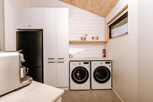 a kitchen with a washer and dryer in it at Kaho - Ohakune Holiday Home with Spa in Ohakune