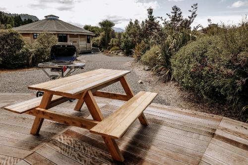a picnic table sitting on a deck with a grill at Kaho - Ohakune Holiday Home with Spa in Ohakune