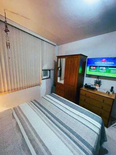 1 dormitorio con 1 cama y TV en Apto com Wi-Fi a 200m da Praia de Copacabana/RJ - Cp4, en Río de Janeiro