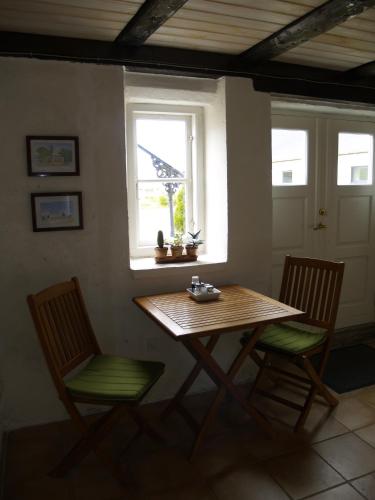 a table and two chairs in a room with a window at Juhl's Bed & Breakfast in Kolding