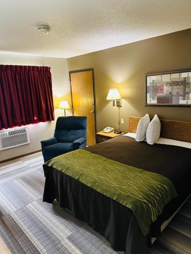 una habitación de hotel con una cama y una silla en Arlington Inn, en Arlington