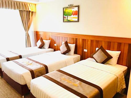 a hotel room with three beds in it at Vinh Plaza Hotel in Vinh