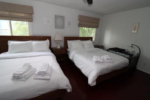 a bedroom with two beds with white towels on them at Cheerful Beach Townhouse in Virginia Beach