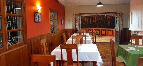 a restaurant with tables and chairs and a painting on the wall at L'anis Etoilé - Hôtel Restaurant in Antsirabe