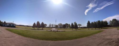 an empty park with trees and a road in the middle at Skyview Motel - Prairie du Sac in Prairie du Sac