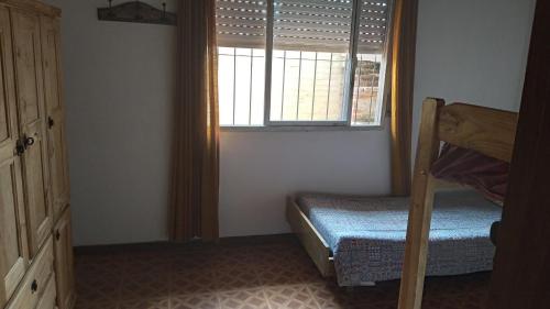 sypialnia z łóżkiem piętrowym i oknem w obiekcie Alquiler de casa w mieście Santa Teresita