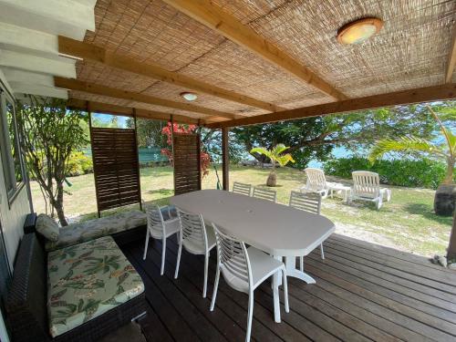a patio with a table and chairs on a deck at MOOREA - Fare Tiki Beach in Haapiti