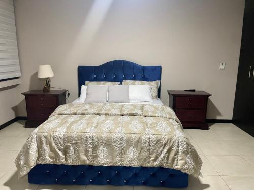 a bedroom with a blue bed with two night stands at Bellini 2 in Guayaquil