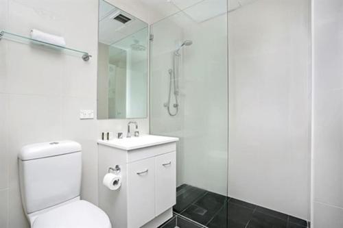 a bathroom with a toilet and a glass shower at CLD01 - 1 bedroom unit - Bridge Street, Sydney CBD in Sydney