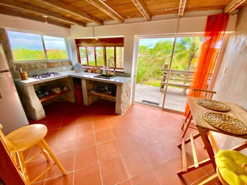 uma cozinha com um balcão, uma mesa e cadeiras em Casa de Orion em Ayangue