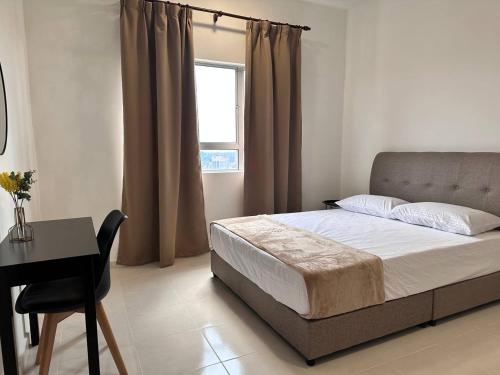 Schlafzimmer mit einem Bett, einem Schreibtisch und einem Fenster in der Unterkunft Cozy Apartment 3 Br CityView In KT Near Drawbridge in Kuala Terengganu