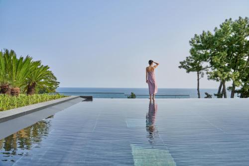 kobieta stojąca na krawędzi basenu w obiekcie JW Marriott Jeju Resort & Spa w mieście Seogwipo