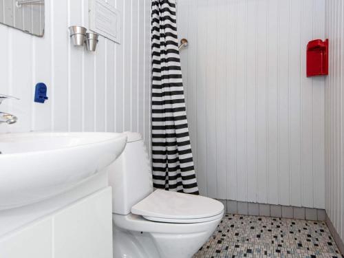 a bathroom with a white toilet and a sink at 4 person holiday home in Sydals in Østerby
