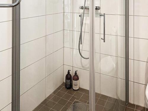 dos botellas de vino sentadas en el suelo de una ducha en Holiday home Sundbyberg en Sundbyberg