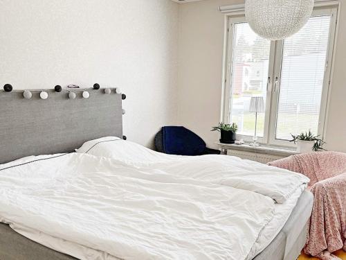 a bedroom with a white bed and a window at Holiday home Sundbyberg in Sundbyberg