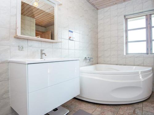 uma casa de banho branca com uma banheira e um lavatório em Holiday home Harboøre XXIII em Harboør