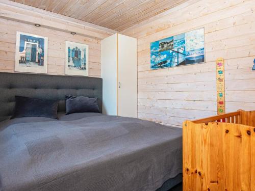 um quarto com uma cama e uma parede de madeira em Holiday home Harboøre XXIII em Harboør