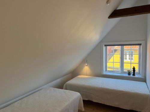 a attic bedroom with two beds and a window at Holiday home Svaneke LXII in Svaneke