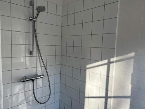 a shower with a shower head in a bathroom at Holiday home Svaneke LXII in Svaneke