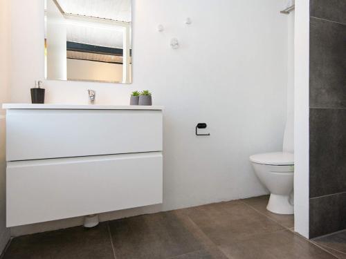 a white bathroom with a sink and a toilet at Holiday home Sydals L in Østerby