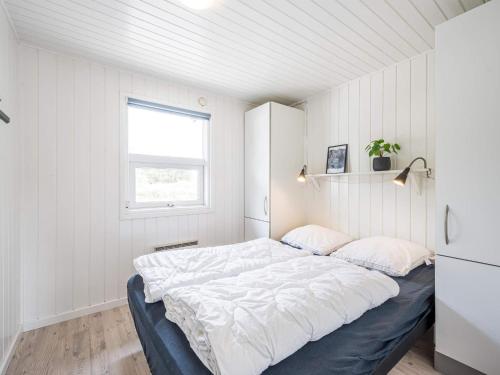 1 dormitorio con 1 cama grande con sábanas blancas en Holiday home Henne CXXXIII en Henne Strand