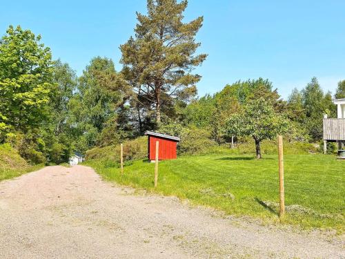 a dirt road with a red shed on the side of a field at 6 person holiday home in UDDEVALLA-By Traum in Uddevalla
