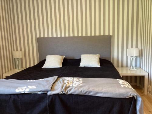 a bedroom with a large bed with black sheets and pillows at 6 person holiday home in UDDEVALLA-By Traum in Uddevalla