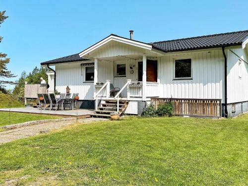 a white house with a porch and a yard at 6 person holiday home in UDDEVALLA-By Traum in Uddevalla