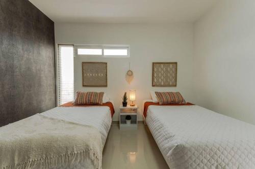 1 dormitorio con 2 camas y ventana en Barcelona Loft, en Chihuahua