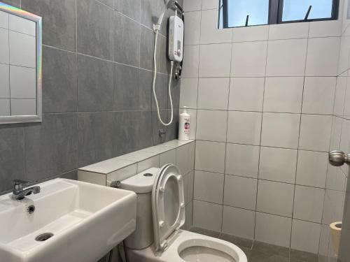 a bathroom with a toilet and a sink at Sandakan Homestay Coastal Serenity 山海绿栖 in Sandakan