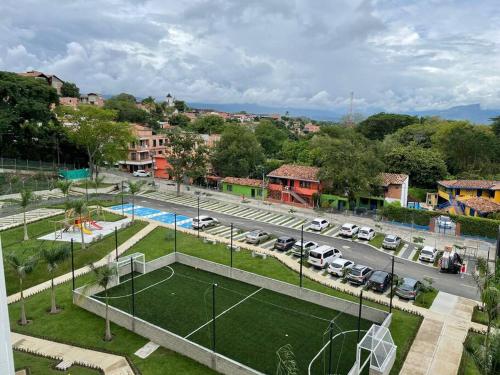 a tennis court in a parking lot with parked cars at Apto Di Sole Santa FeAntioquia in Santa Fe de Antioquia
