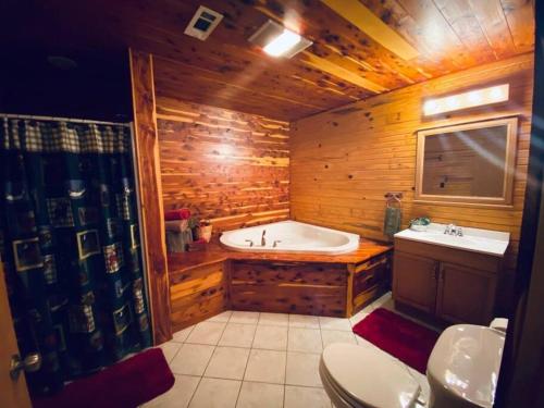 uma casa de banho em madeira com uma banheira e um lavatório em The Presidential Barndominium in the Stable at Bear Mountain em Eureka Springs