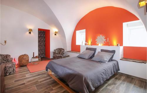 a bedroom with a bed and an orange wall at Nice Home In Sauzet in Sauzet