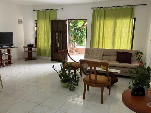 a living room with a couch and a tv at Casa Encanto Cartagena Colombia in Cartagena de Indias