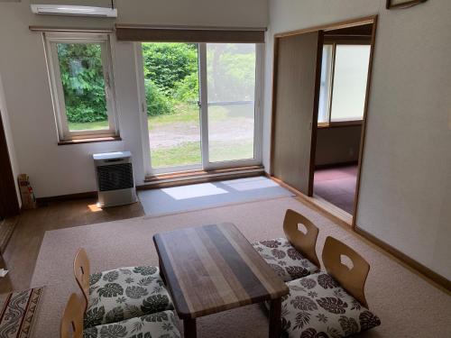a living room with a wooden table and chairs at Furano Rental House in Furano