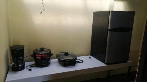 a counter with a television and a coffee maker and a appliance at Cabinas Lawson in Puerto Jiménez