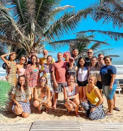 a group of people posing for a picture on the beach at Full Moon Village Resort in Mui Ne